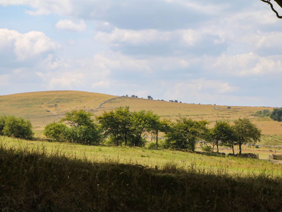 A view of hills and trees with a cloudy sky at Little Moorgate in Okehampton