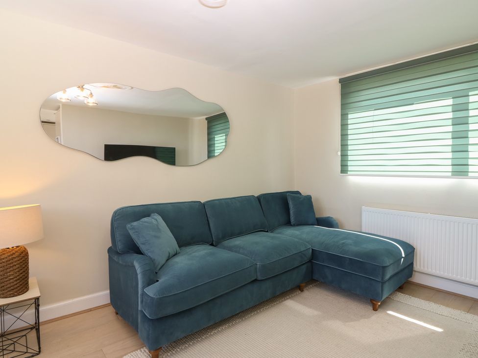 A living room with a sofa and lamp at The Herring's Lean in Eyemouth