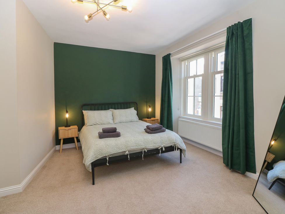 A bedroom with a bed and bedside table at The Herring's Lean in Eyemouth