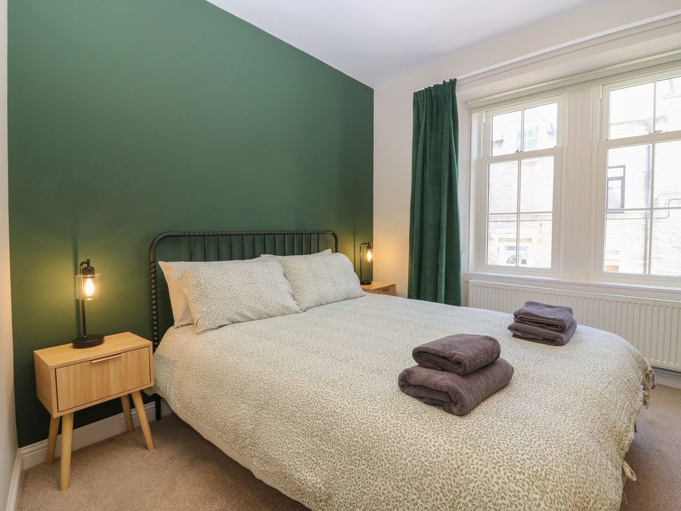 A bedroom with a bed and bedside table at The Herring's Lean in Eyemouth