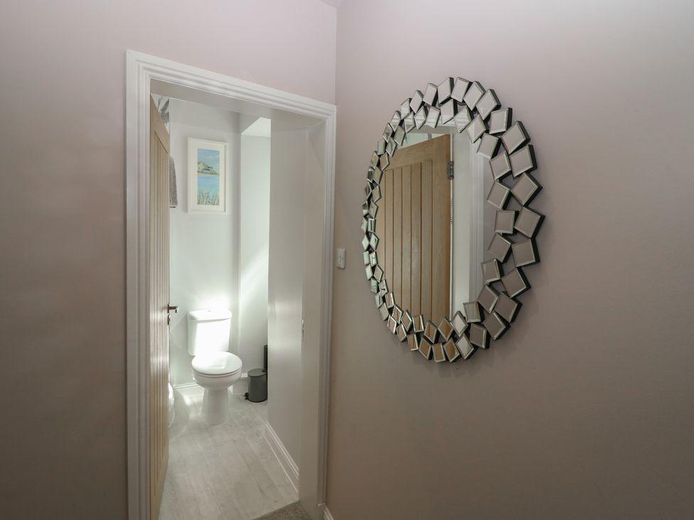 A bathroom with a toilet and mirror at The Herring's Lean in Eyemouth