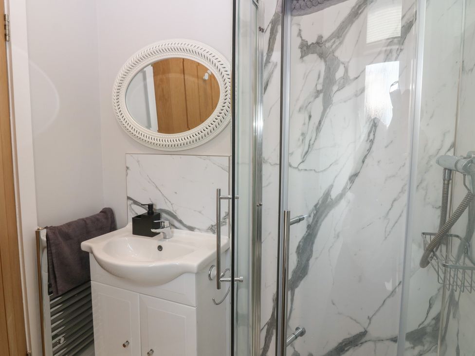 A bathroom with a shower and sink at The Herring's Lean in Eyemouth