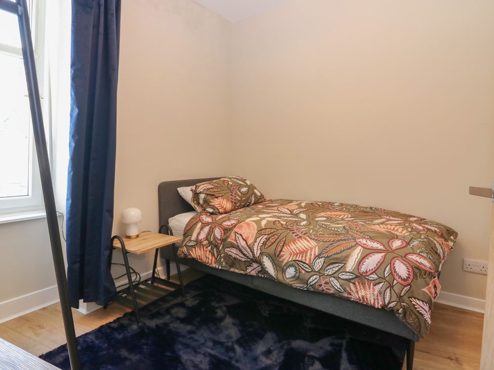 A bedroom with a bed and nightstand at The Herring's Lean in Eyemouth