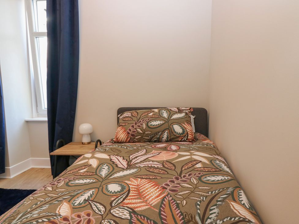 A bedroom with a bed and lamp at The Herring's Lean in Eyemouth