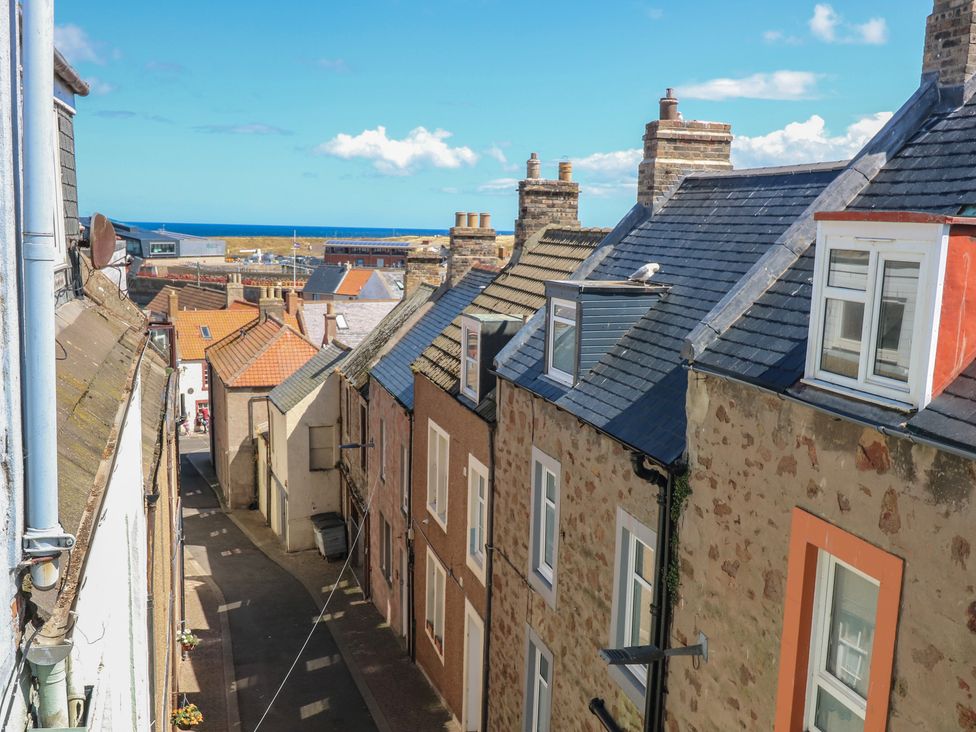 A view of buildings and roofs with ocean in the background at The Herring's Lean Eyemouth