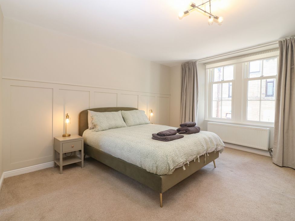 A bedroom with a bed and window at The Herring's Lean in Eyemouth