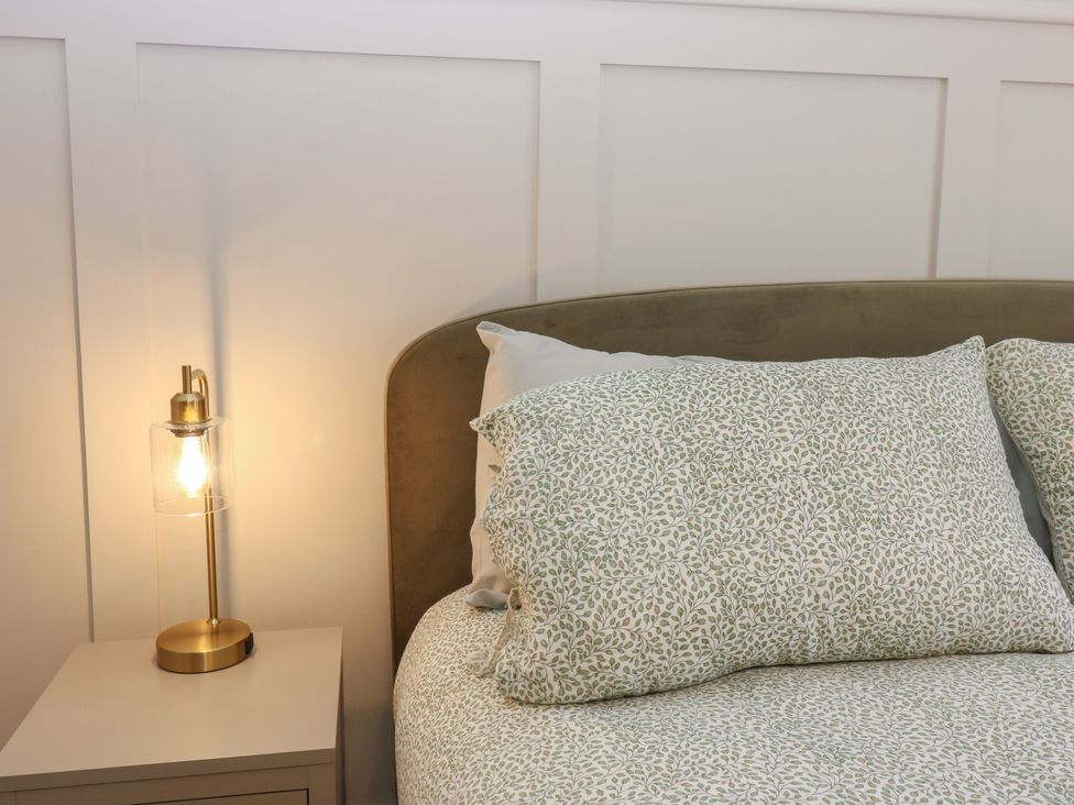 A bedroom with a bed and lamp at The Herring's Lean in Eyemouth