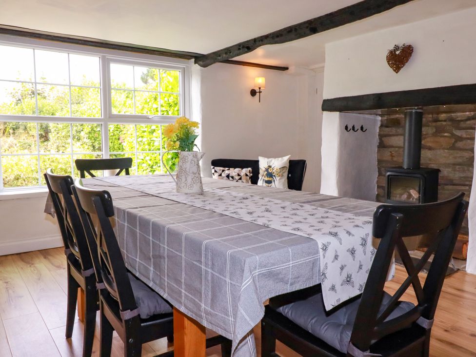 A dining room with a table and chairs at Honey Bee Cottage Menheniot