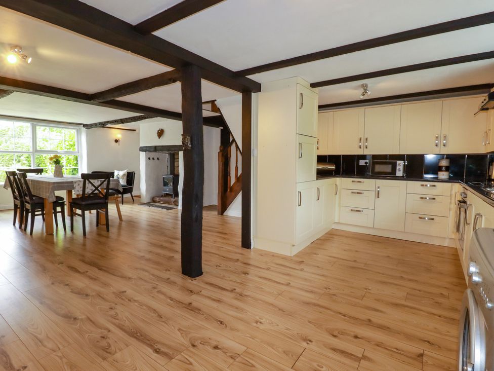A kitchen with dining area and staircase at Honey Bee Cottage in Menheniot