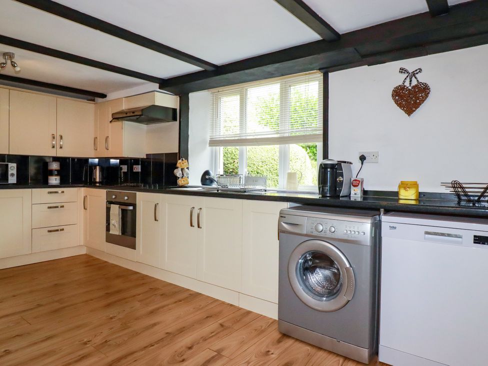 A kitchen with appliances and cabinets at Honey Bee Cottage in Menheniot