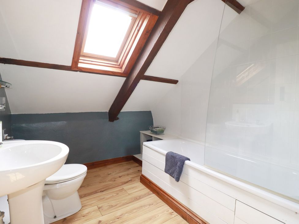 A bathroom with a sink and bathtub at Honey Bee Cottage in Menheniot