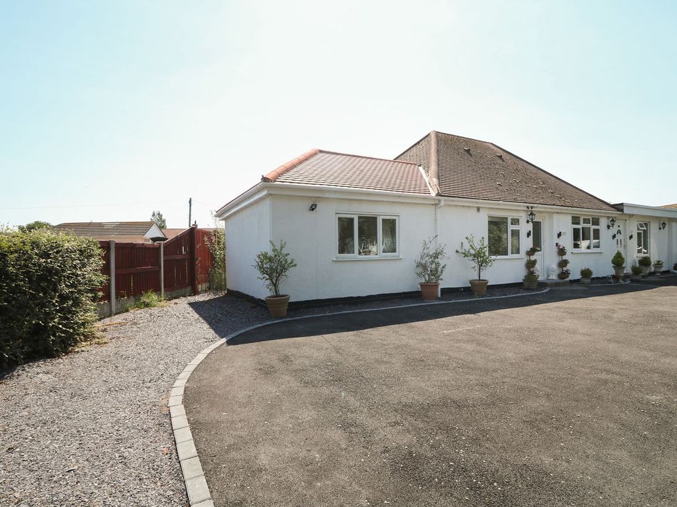A house with a driveway and plants outside at Beachway in Holywell