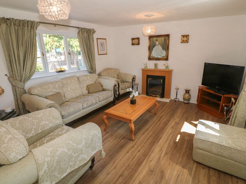 A living room with sofas and a television at Beachway in Holywell
