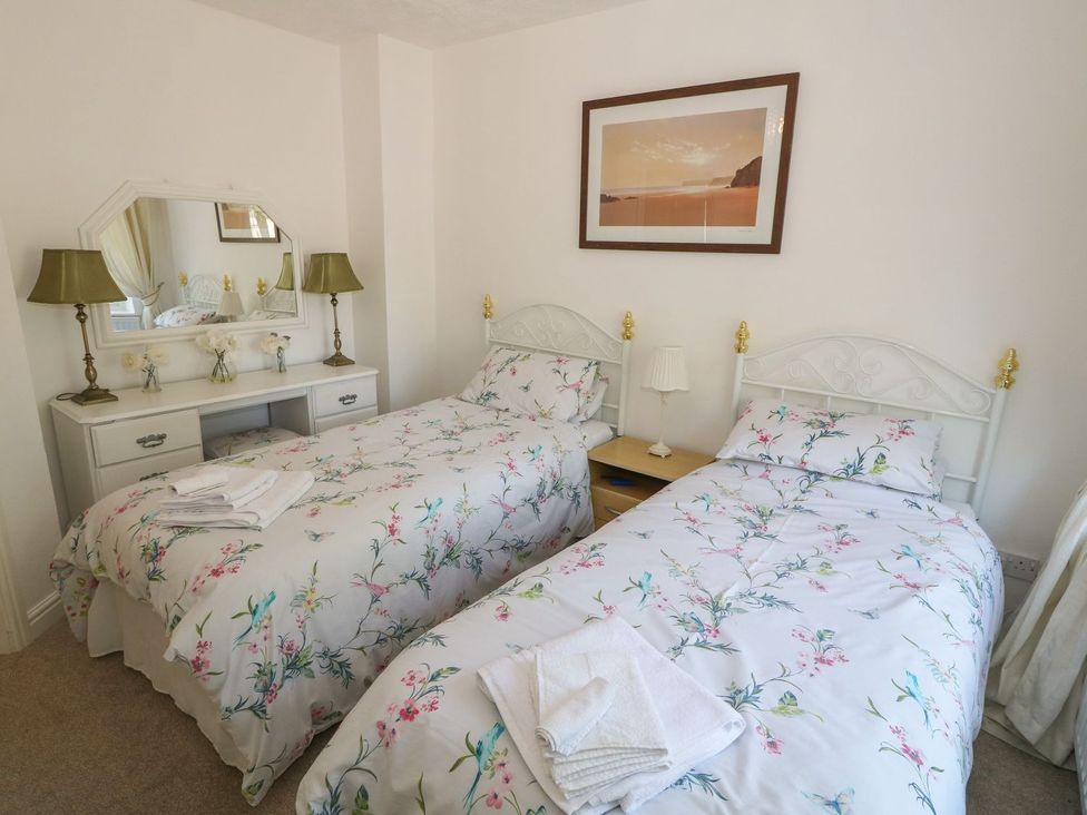 A bedroom with twin beds and a dressing table at Beachway in Holywell