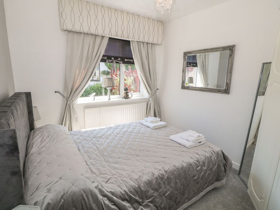 A bedroom with a bed and window at Beachway in Holywell