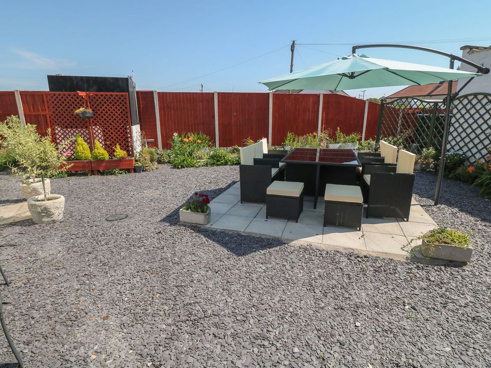 A garden with a seating area and table at Beachway in Holywell