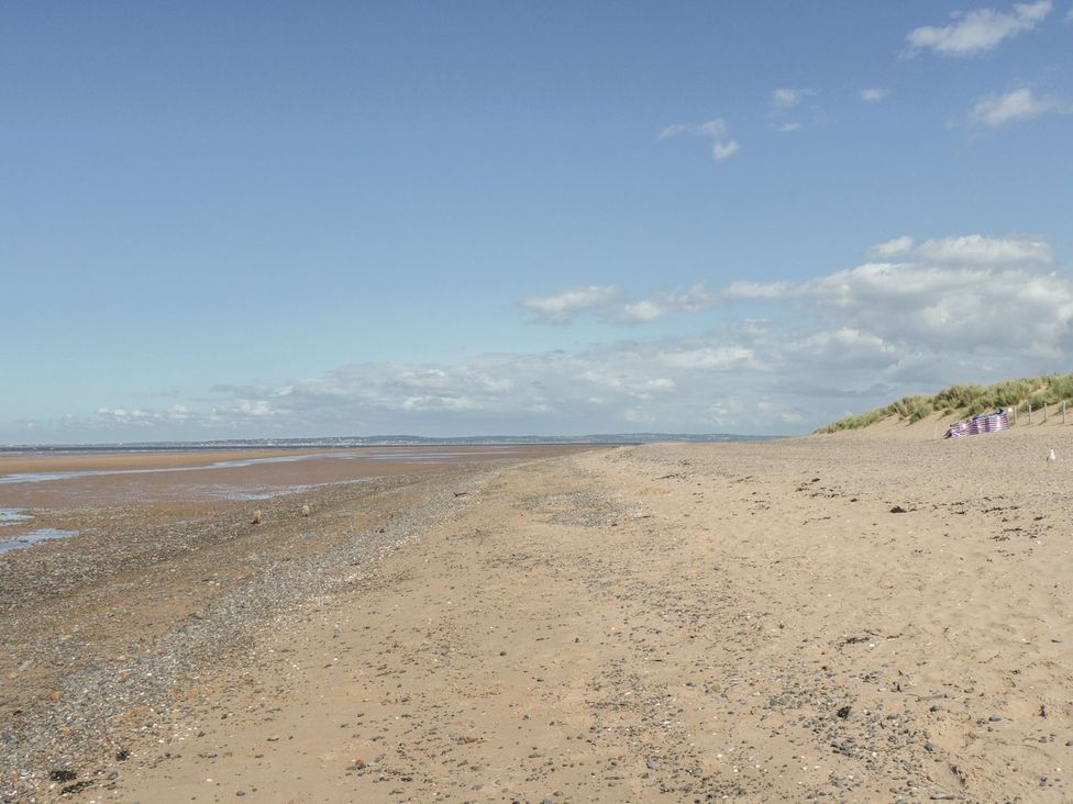 A beach with sand and water and dunes at Beachway in Holywell