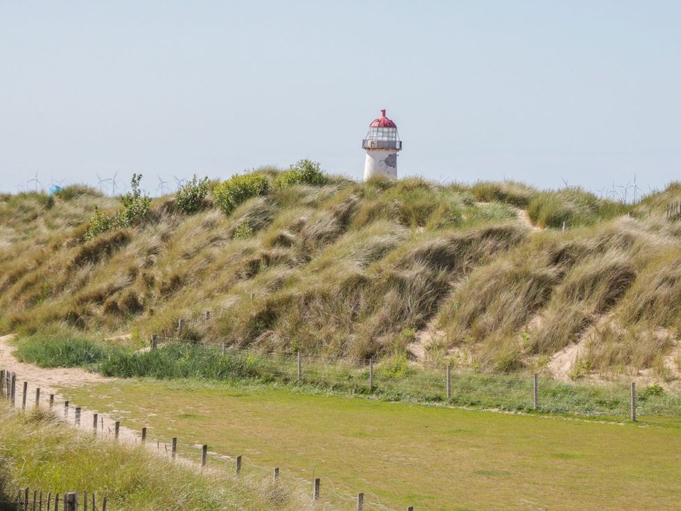 A lighthouse among sand dunes at Beachway in Holywell