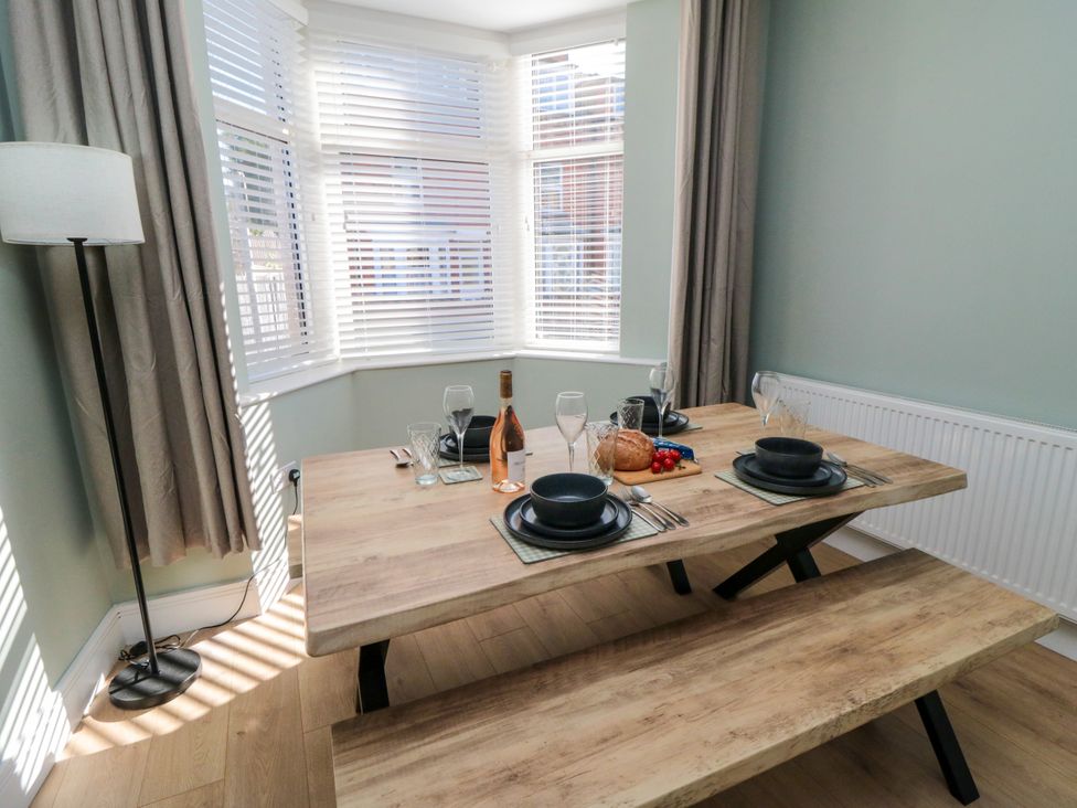 A dining room with a wooden table and seating at Portobell House in Bridlington