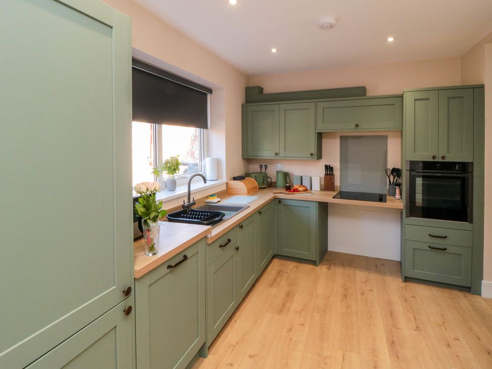 A kitchen with cabinets and sink at Portobell House in Bridlington