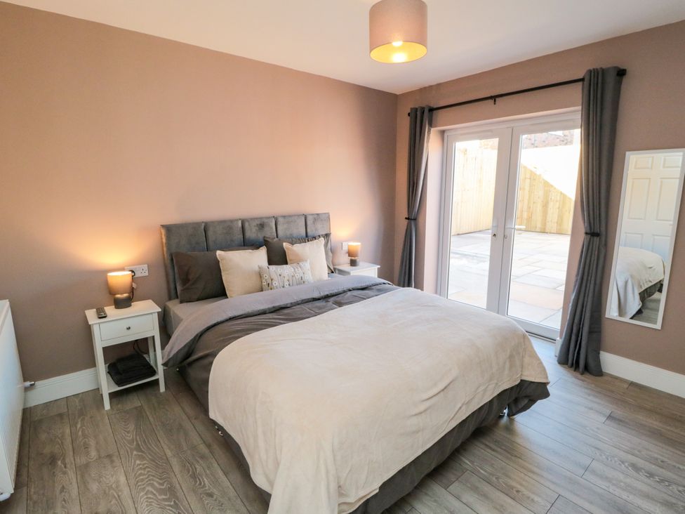 A bedroom with a bed and sliding doors to an outdoor area at Portobell House in Bridlington