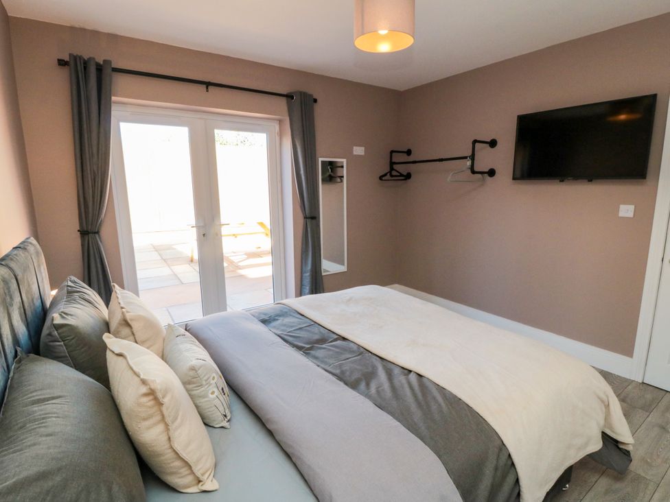 A bedroom with a bed and television at Portobell House in Bridlington