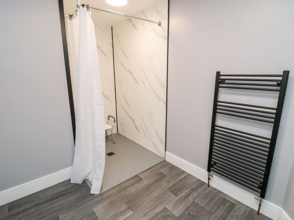 A wet room with a shower and towel rail at Portobell House in Bridlington
