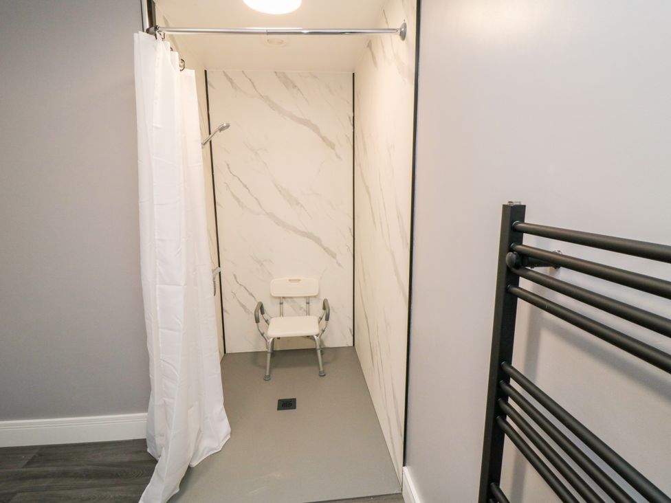 A shower with a seat and towel radiator at Portobell House in Bridlington