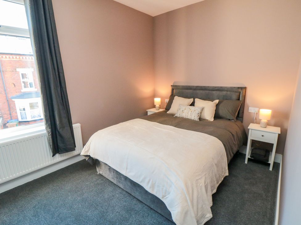 A bedroom with a bed and bedside tables at Portobell House in Bridlington