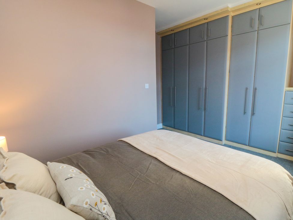 A bedroom with a bed and storage unit at Portobell House in Bridlington