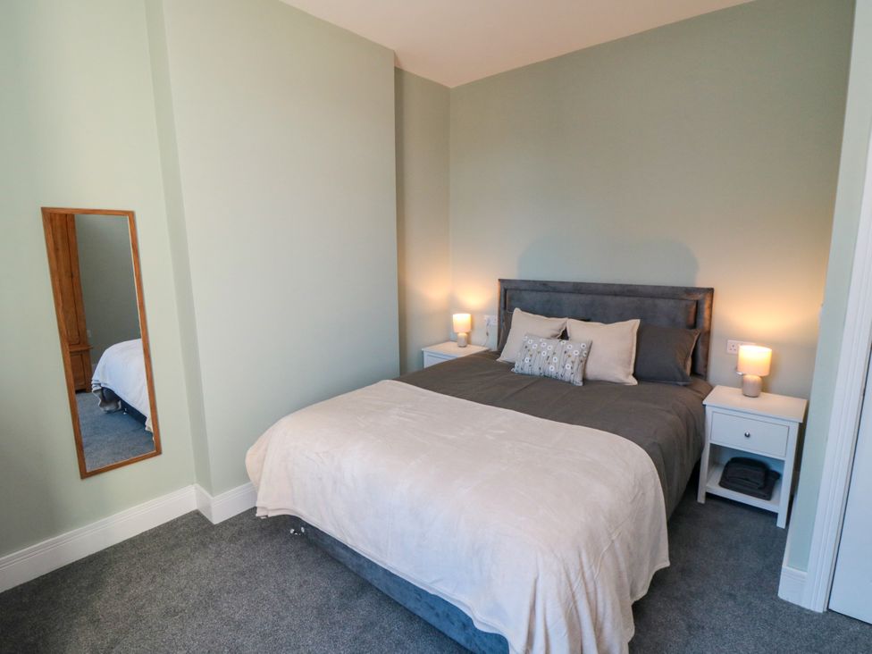 A bedroom with a bed and nightstands at Portobell House in Bridlington