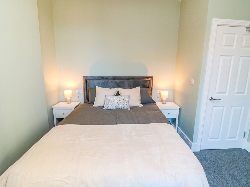 A bedroom with a bed and bedside tables at Portobell House in Bridlington