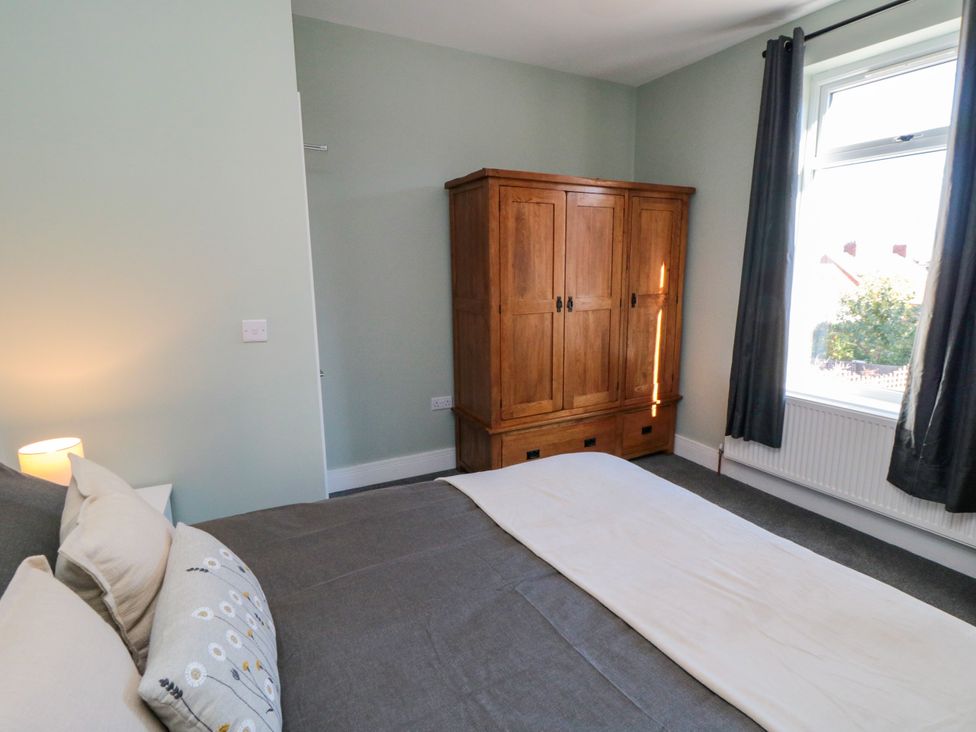 A bedroom with a bed and wardrobe at Portobell House in Bridlington