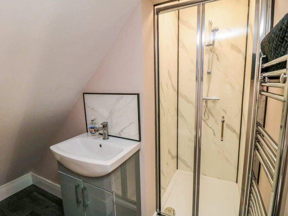 A bathroom with a shower enclosure and wash basin at Portobell House in Bridlington