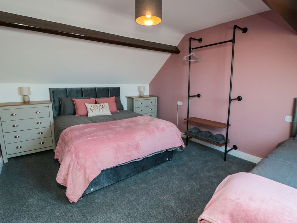 A bedroom with a bed, nightstands, and a dresser at Portobell House in Bridlington