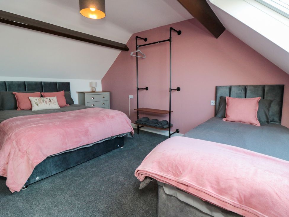 A bedroom with two beds and a shelf at Portobell House in Bridlington