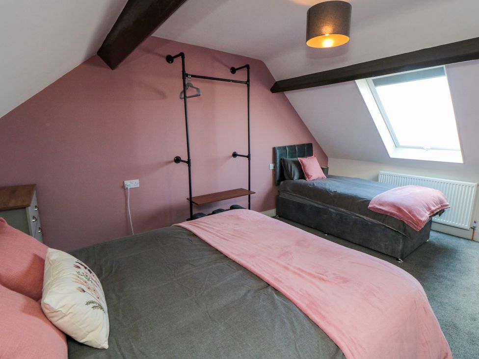 A bedroom with two beds and a shelf at Portobell House in Bridlington