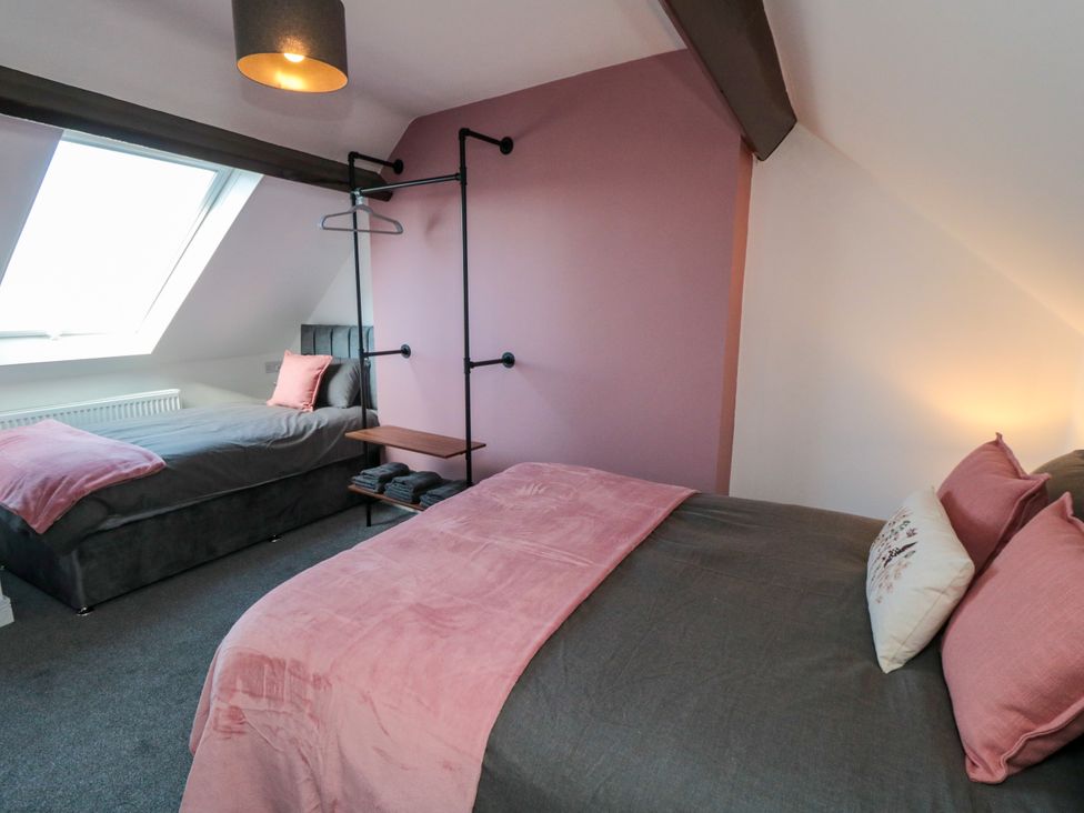 A bedroom with two beds and a hanging rack at Portobell House in Bridlington