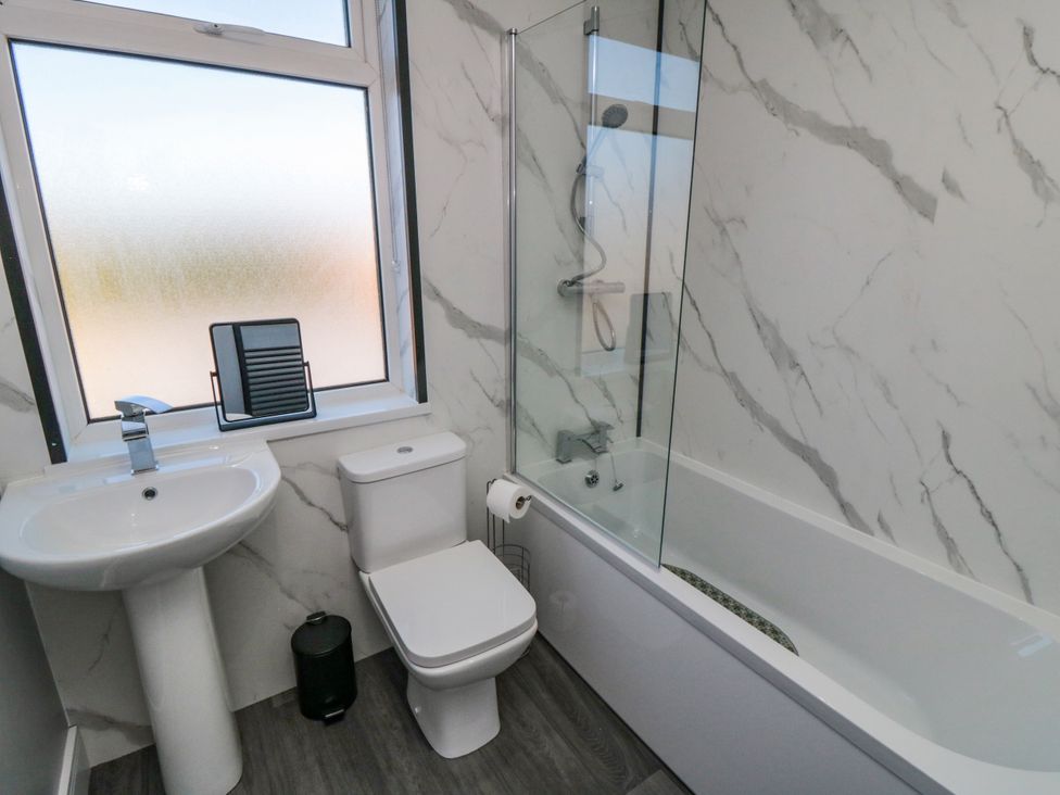 A bathroom with a bath, sink, and toilet at Portobell House in Bridlington