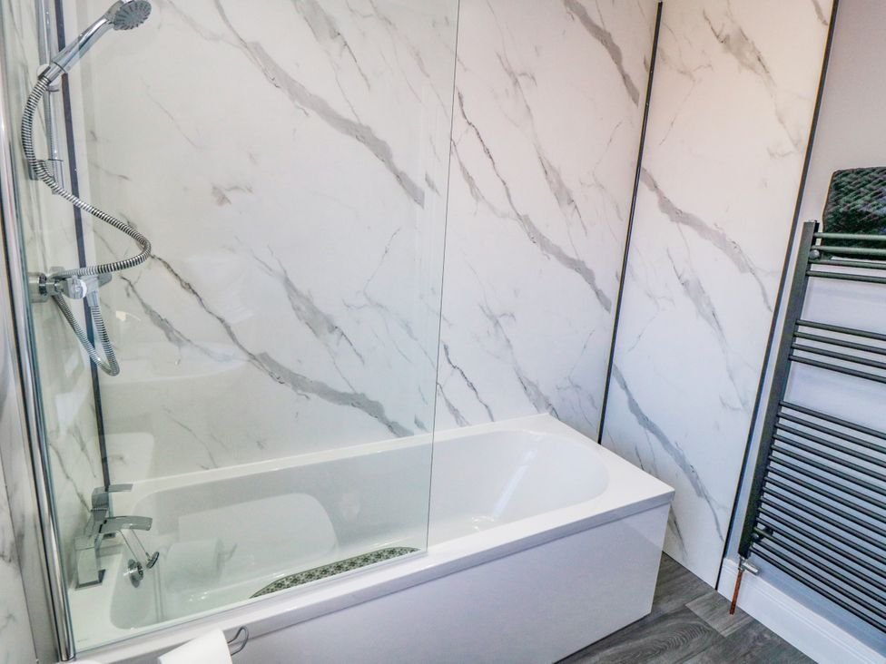 A bathroom with a bathtub and shower at Portobell House in Bridlington