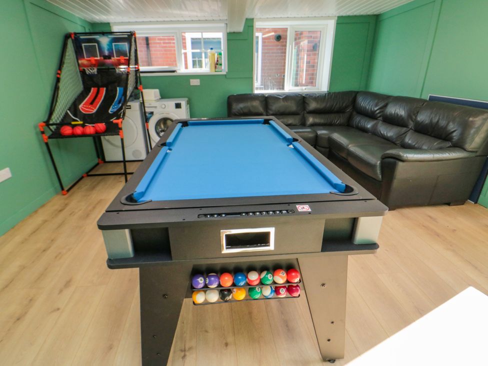 A recreation room with a pool table and basketball game in Portobell House, Bridlington