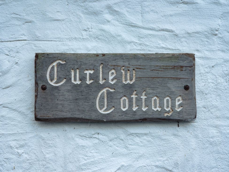 A sign displaying the name Curlew Cottage