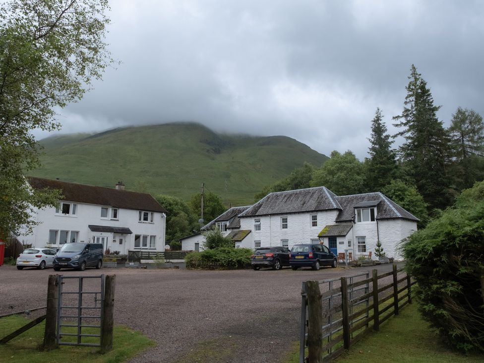 An outdoor view of houses and vehicles at Curlew Cottage in Crianlarich