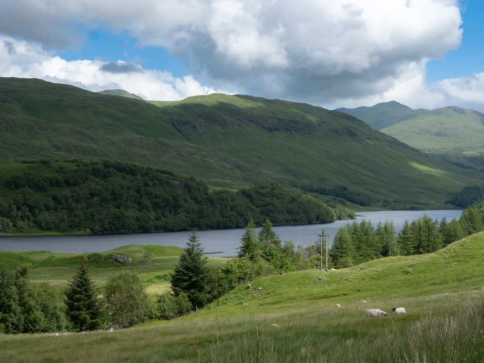 A landscape view with mountains and a water body at Curlew Cottage Crianlarich