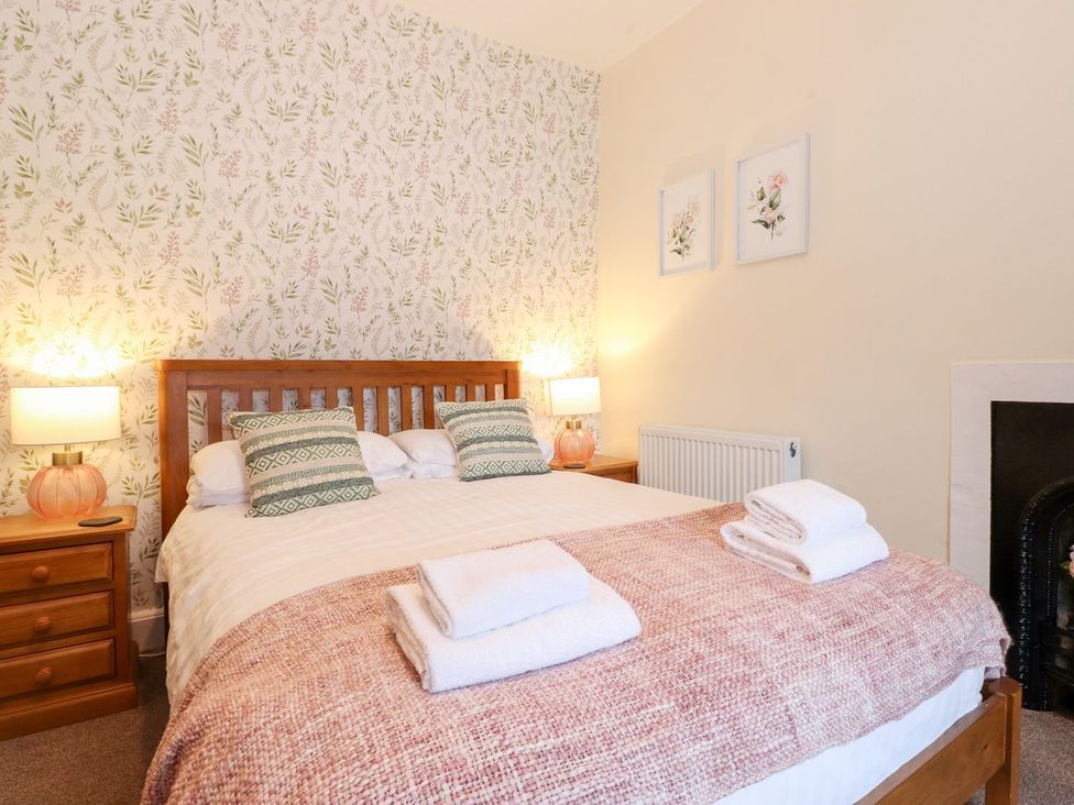 A bedroom with a bed and bedside tables at Irt Cottage Seascale