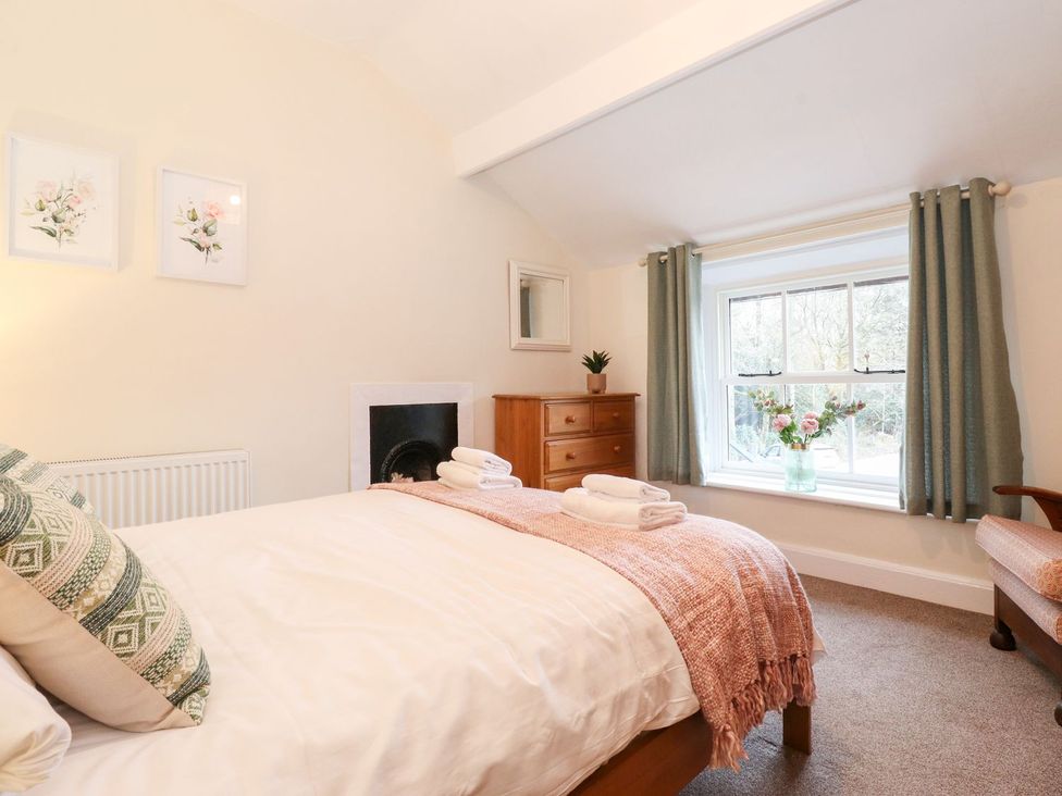 A bedroom with a bed and window at Irt Cottage in Seascale