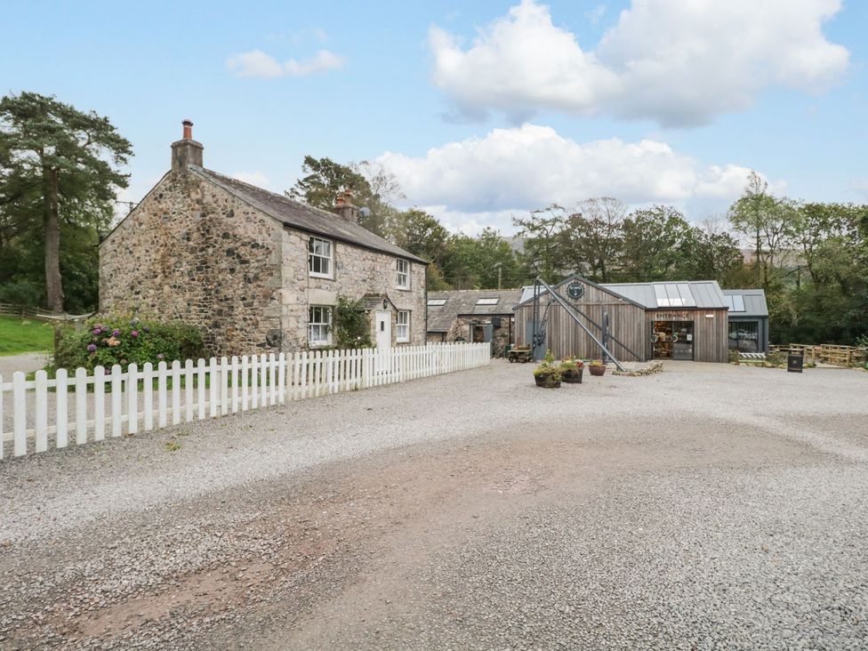 An outdoor view of a house and storage building at Irt Cottage Seascale