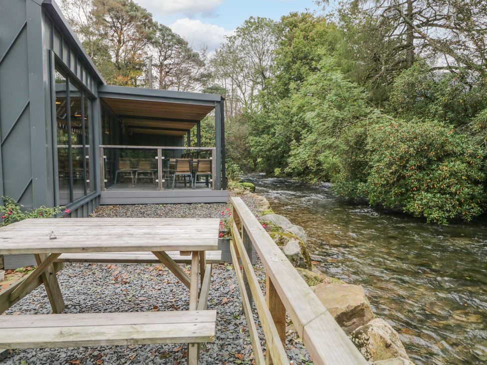 An outdoor seating area with a table by a river at Irt Cottage Seascale