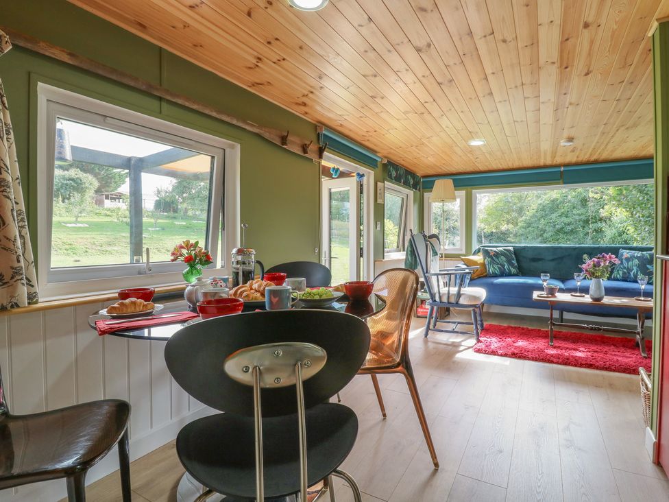 A living room with a dining table and sofa at Orchard Lodge in Dover