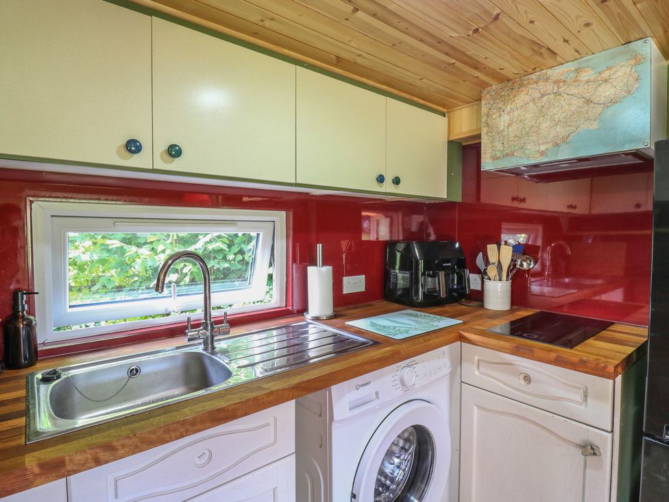 A kitchen with a sink and washing machine at Orchard Lodge in Dover